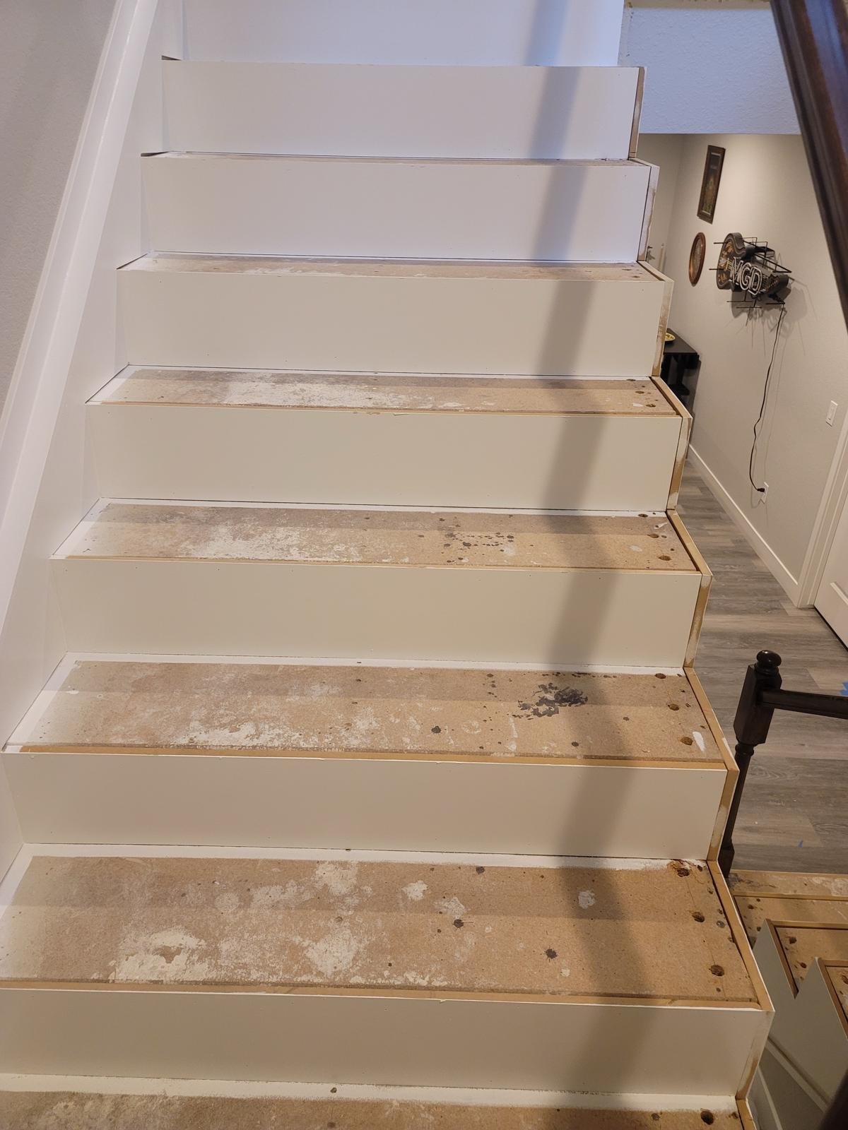 a white stairs with wood flooring
