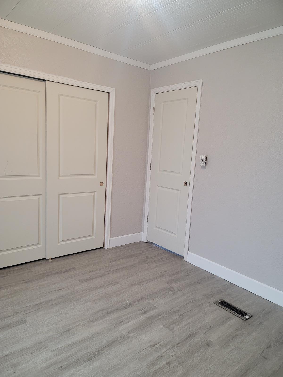 a room with two doors and a wood floor