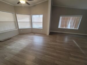 a room with a ceiling fan and windows